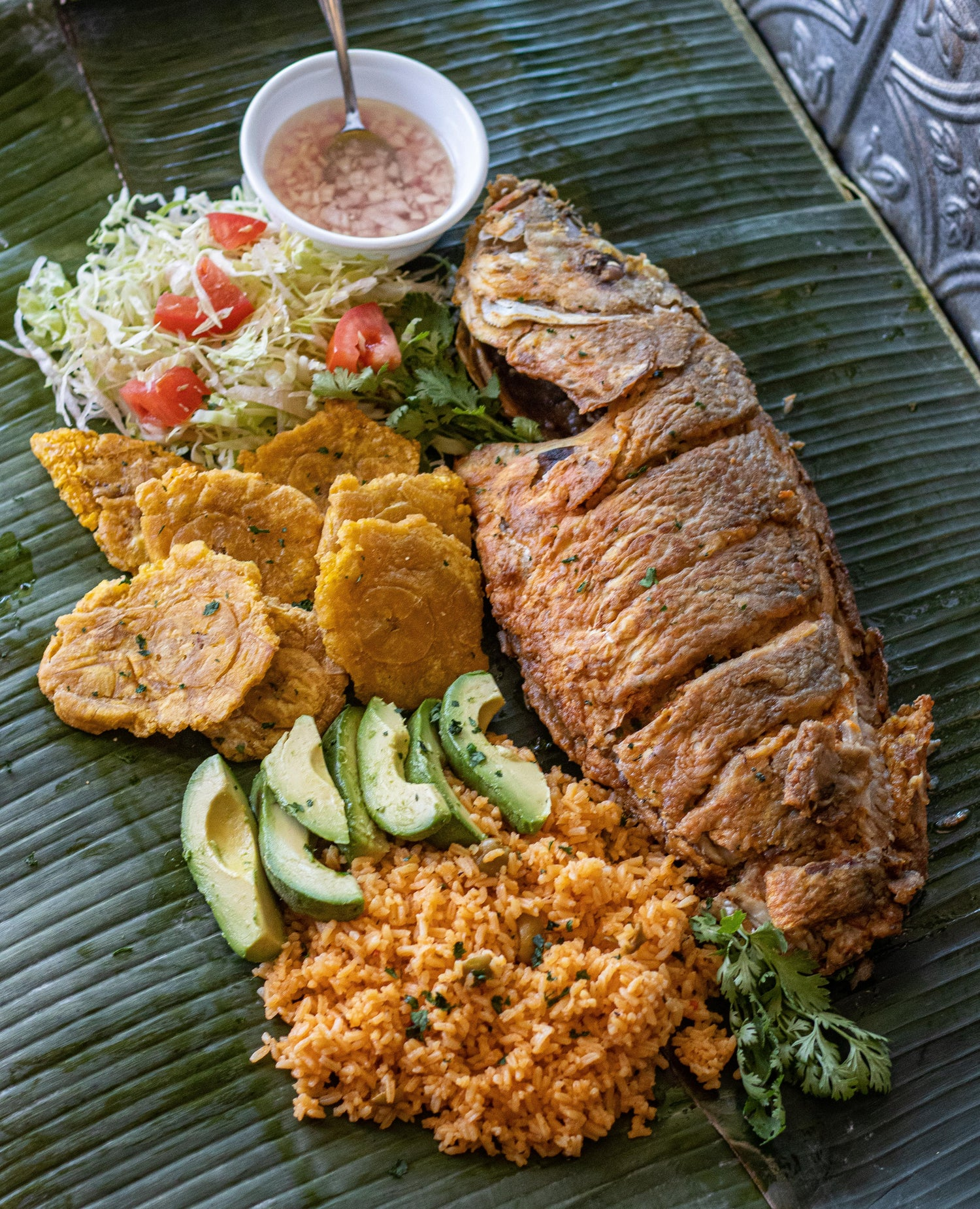Pwason Fri, a whole fried fish marinated in Epice complète à tout usage pimentée served with fried plantains and avocado