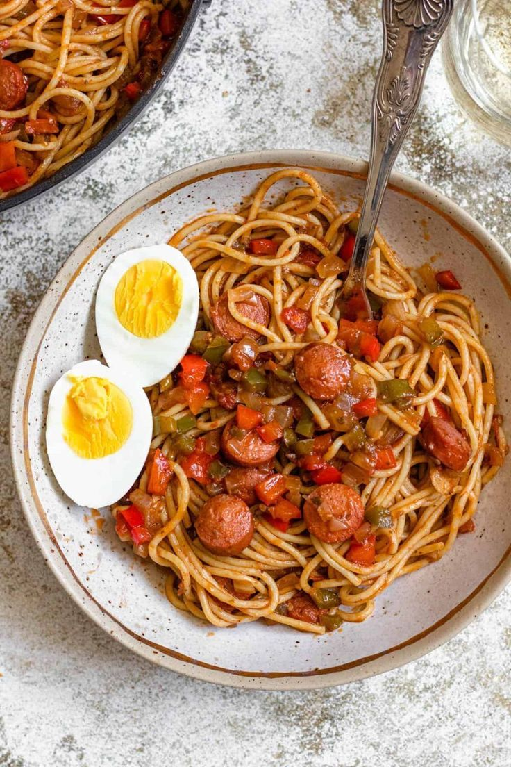 Haitian spaghetti prepared with a rich tomato base, sautéed onions, bell peppers, sliced sausages, and boiled eggs.